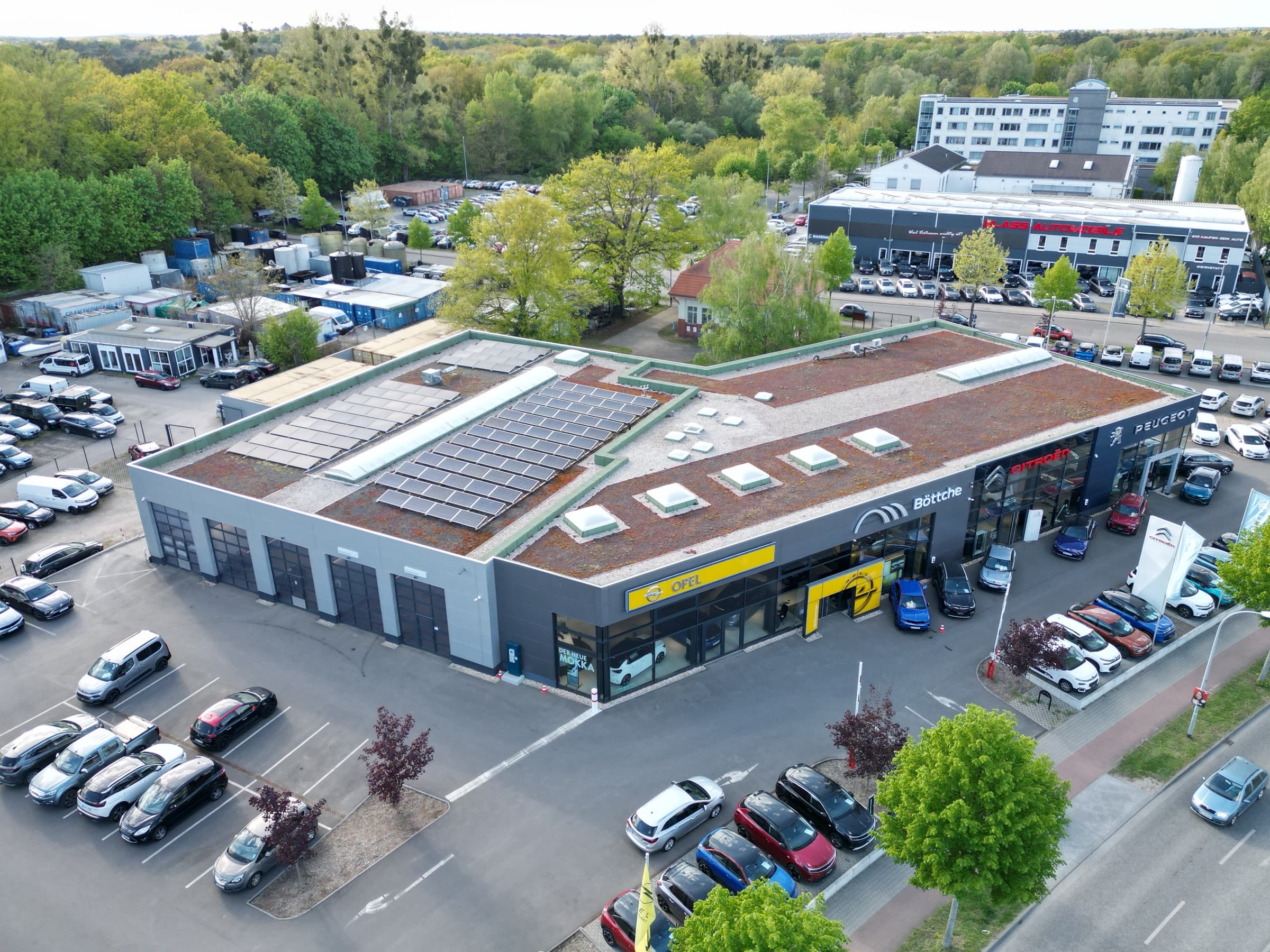 Luftaufnahme des Autohauses in Teltow mit Photovoltaik auf dem begrünten Flachdach