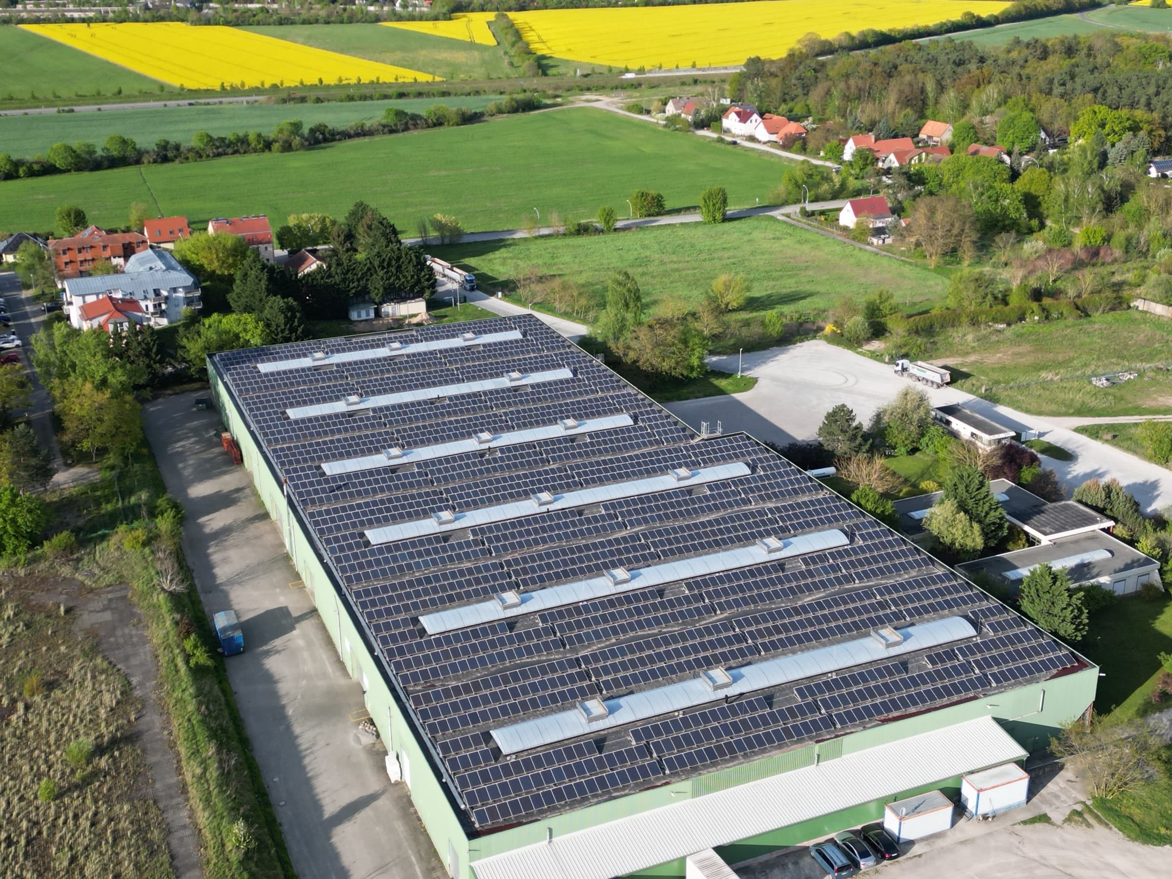 Luftaufnahme der repowerten Hallendächer in Güterfelde zwischen Feldern und Wohnhäusern