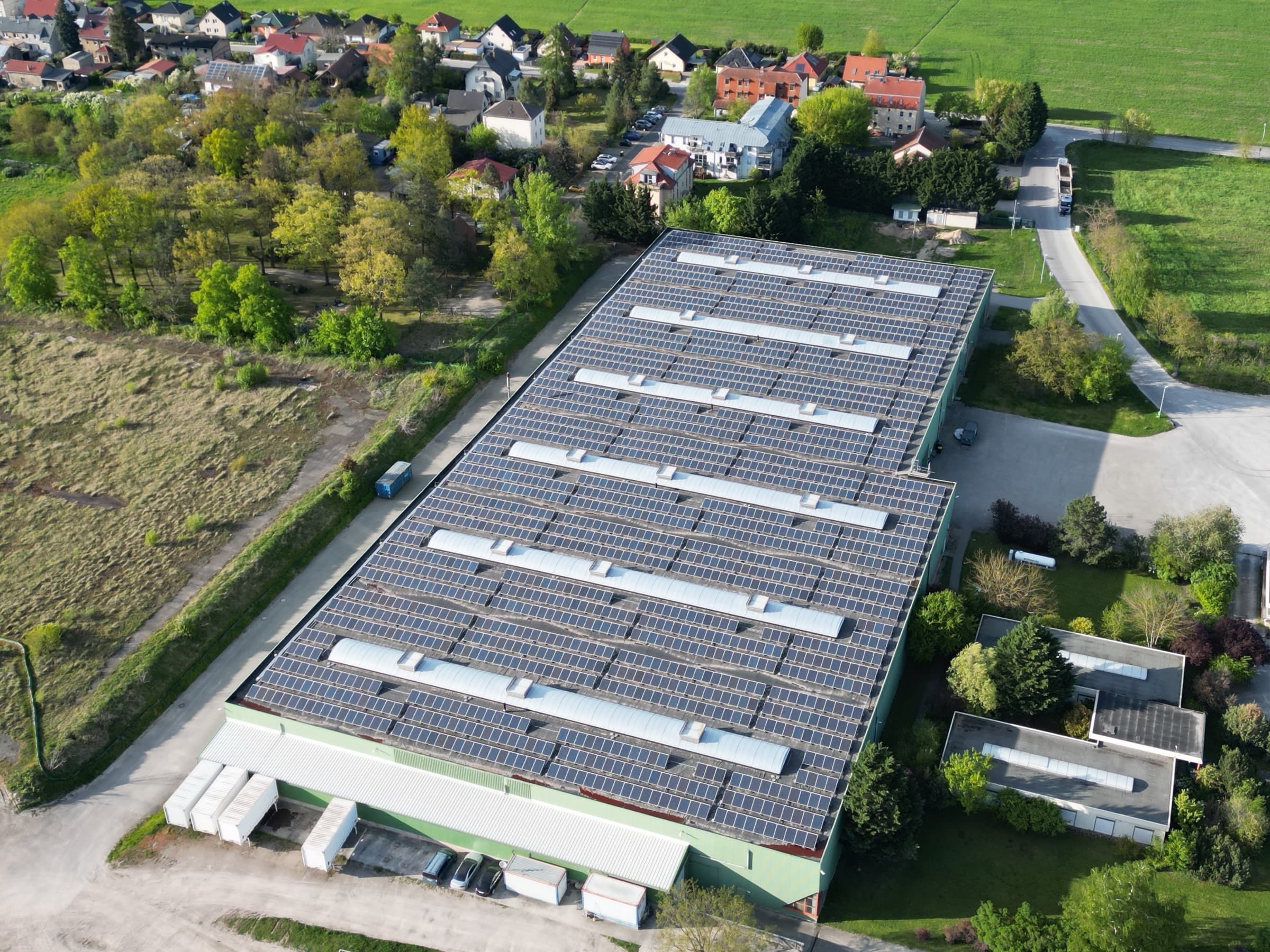 Luftaufnahme der voll belegten Hallendächer in Güterfelde nach dem Repowering