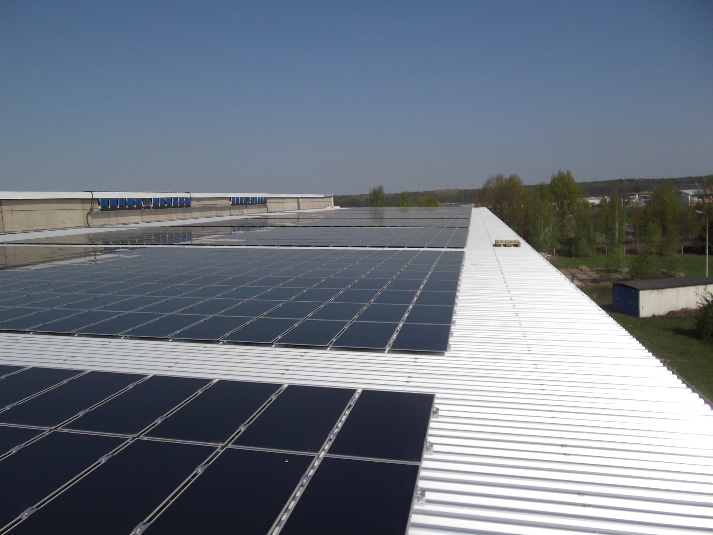 Kamenz: flach verlegte PV-Module auf weißem Hallendach, Anlage mit 1,08 MWp