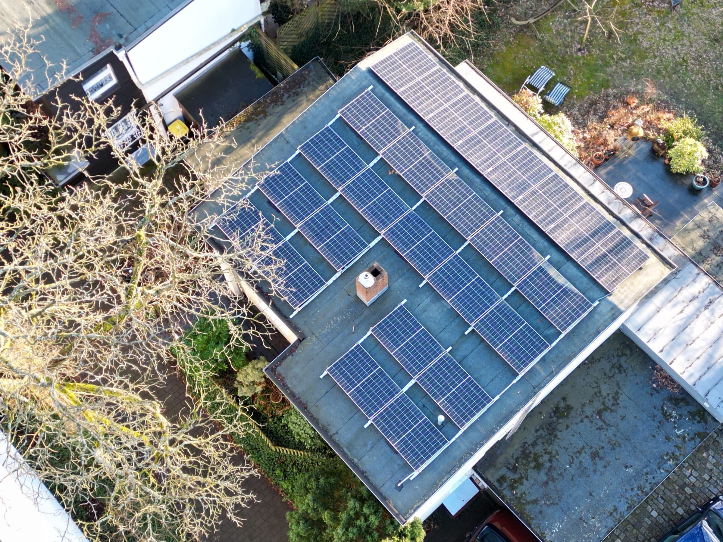 Privates Flachdach mit aufgeständerten Photovoltaik-Modulen, Garten und Terrasse